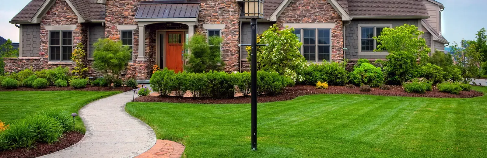 stone home with nice front lawn